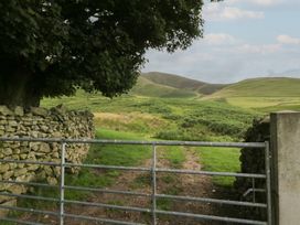 A gate opening to a pathway leading to hills at Howgill Head in Kendal