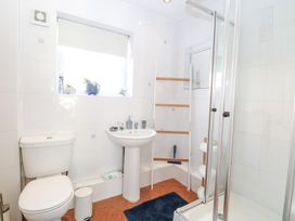 A bathroom with a toilet sink shower and window with plants at 98 Waterside Park in Corton