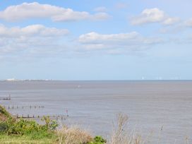 A coastal view with the sea in the foreground and wind turbines on the horizon at 98 Waterside Park in Corton