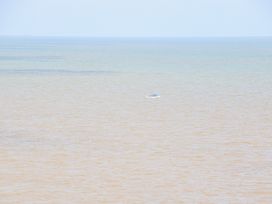 A small boat floating on the sea with a horizon in the background at 98 Waterside Park in Corton
