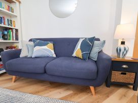A living room with a sofa and bookshelf at Belle's View in Scarborough