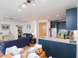 A living room with bookshelves and kitchen appliances at Belle's View in Scarborough