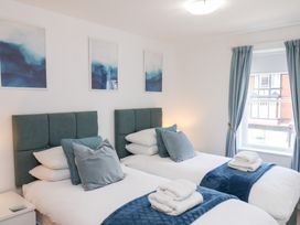 A bedroom with twin beds and pictures on the wall at Belle's View in Scarborough