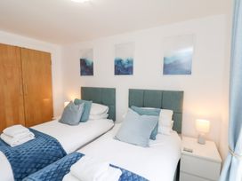A bedroom with two beds and a wardrobe at Belle's View in Scarborough