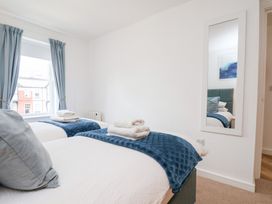 A bedroom with two beds and a mirror at Belle's View in Scarborough