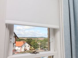 A window with a roller blind and a view of houses at Belle's View in Scarborough