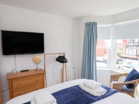 A bedroom with a television and a clothing rack at Belle's View in Scarborough