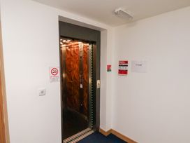 A corridor with an elevator and signs at Belle's View Scarborough