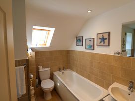 A bathroom with a bathtub, toilet, and sink at Rosemarie Annexe in Axminster