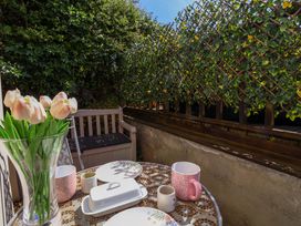A table with tulips and mugs on a patio at Rosemarie Annexe in Axminster