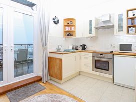 A kitchen with cabinets and appliances at Captain’s Quarters in Porthmadog