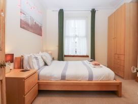 A bedroom with a bed and wardrobe at Captain’s Quarters in Porthmadog