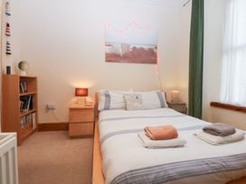 A bedroom with a bed and bookshelf at Captain’s Quarters in Porthmadog