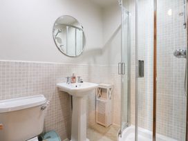 A bathroom with shower, sink, and toilet at Captain’s Quarters in Porthmadog