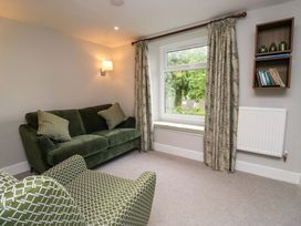 A living room with a sofa, armchair and window at Dove Cottage in Ambleside