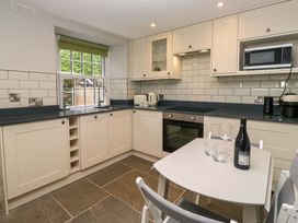 A kitchen with cabinets and appliances at Dove Cottage in Ambleside