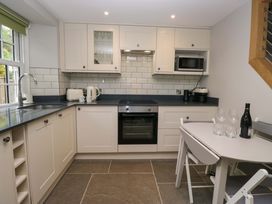 A kitchen with appliances and dining table at Dove Cottage in Ambleside