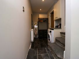 A laundry room with a washer and ironing board at Dove Cottage in Ambleside