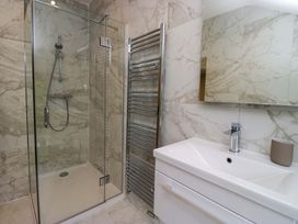 A bathroom with a shower, sink and towel rail at Dove Cottage in Ambleside
