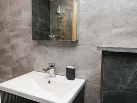 A bathroom with a sink, faucet and mirror at Dove Cottage in Ambleside