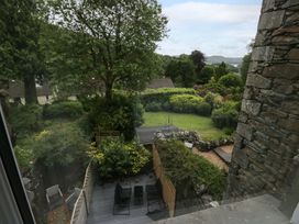 A garden view with trees and chairs at Dove Cottage in Ambleside