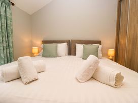A bedroom with bed, towels, and bedside lamps at Dove Cottage in Ambleside