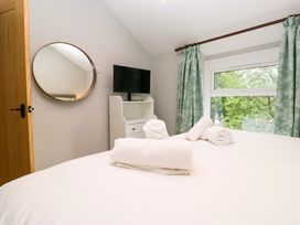 A bedroom with a bed, television, and mirror at Dove Cottage in Ambleside