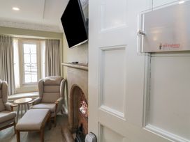 A sitting room with two chairs and a television at The Babbling Brook Nook in Chudleigh