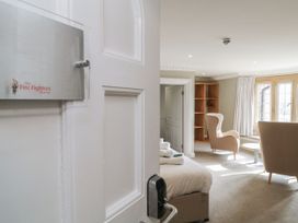 A bedroom with a bed and chairs at Chudleigh Charm in Chudleigh