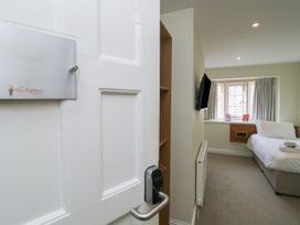 A bedroom with a bed and window at The Woodland Hideaway in Chudleigh