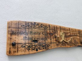 A wooden sign for Bramley Manor Cottage in Flamborough