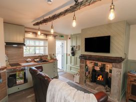 A kitchen with a fireplace and TV at Driftwood in Flamborough
