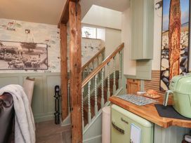A kitchen with a staircase and framed picture at Driftwood in Flamborough