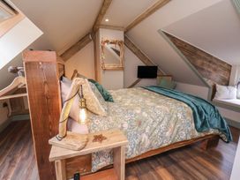 A bedroom with a wooden bed and a television at Driftwood in Flamborough