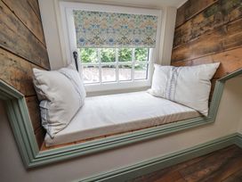 A snug area with a window seat and cushions at Driftwood in Flamborough