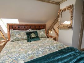 A bedroom with a bed and mirror at Driftwood in Flamborough