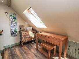 An attic space with a desk and a stool at Driftwood in Flamborough