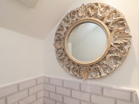A decorative mirror on the wall in a bathroom at Driftwood in Flamborough