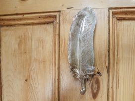 A decorative feather hook on a wooden door at Driftwood Flamborough