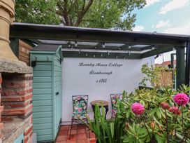 A garden with a table and chairs at Bramley Manor Cottage in Flamborough