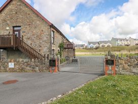A stone building with a gate and staircase at The Coach House in Broad Haven