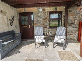 An outdoor seating area with chairs and a table at Puffin Nook in Broad Haven