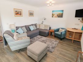 A living room with seating and decor at Puffin Nook in Broad Haven