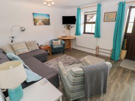 A living room with a sofa and television at Puffin Nook in Broad Haven