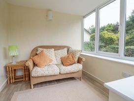 A conservatory with a sofa and a lamp at Hafod in Llangollen