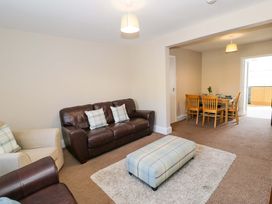 A living room with a sofa and a dining table at Bryn Hyfryd in Conwy
