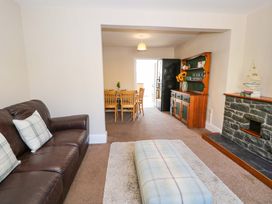 A living room with a sofa and a dining area at Bryn Hyfryd in Conwy