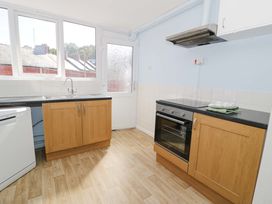 A kitchen with cabinets and appliances including a sink and oven at Bryn Hyfryd in Conwy