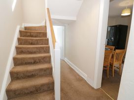 A hallway with stairs leading up and view of kitchen at Bryn Hyfryd in Conwy