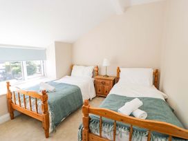 A bedroom with two beds and a nightstand at Bryn Hyfryd in Conwy